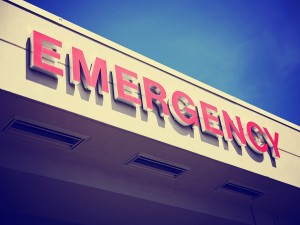 the front entrance sign to an emergency room department in a city hospital toned with a retro vintage instagram filter effect app or action