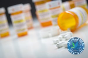 Variety of Medicine Bottles Behind Pills Spilling From Fallen Bo